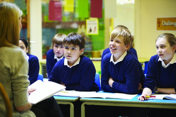 A classroom with rows of attentive students facing a teacher